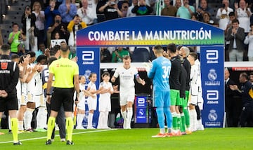 Toni Kroos, recibe el reconocimiento de los jugadores de ambos equipos y aficionados en el estadio Santiago Bernabéu. En la imagen, el futbolista alemán atraviesa con honores el pasillo formado por los conjuntos del Real Madrid y Betis.