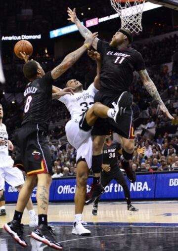 Los jugadores de los Heat de Miami Michael Beasley (i) y Chris Anderson (d) bloquean a Boris Diaw, de los Spurs de San Antonio, durante su partido de la NBA disputado en el AT&T Center en San Antonio, Texas (EE.UU.).