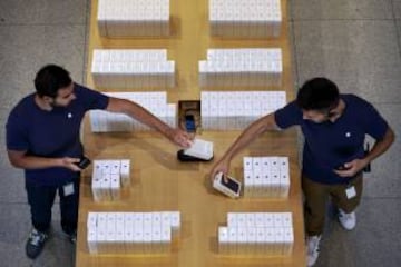 El personal de la tienda de la Puerta del Sol en Madrid prepara los teléfonos ante la llegada de los primeros compradores.