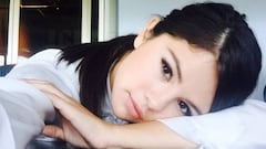 La artista estadounidense Selena Gomez posando recostada sobre una mesa.