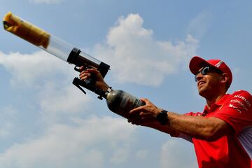 Sebastian Vettel lanzando camisetas a los aficionados presentes en el circuito. 