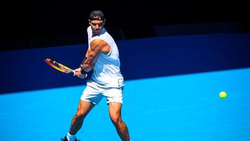 Rafa Nadal arma un rev&eacute;s durante un entrenamiento previo al Open de Australia.