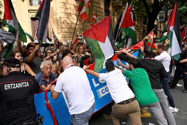 El personal de la Vuelta y agentes de la Ertzaintza de la policía regional vasca mantienen barreras ante los manifestantes propalestinos durante la etapa de hoy. 
