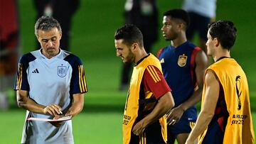 Spain's coach Luis Enrique (L) talks with players during a training session at the Qatar University training ground in Doha on November 30, 2022, on the eve of the Qatar 2022 World Cup football match between Japan and Spain. (Photo by JAVIER SORIANO / AFP)