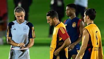 Spain's coach Luis Enrique (L) talks with players during a training session at the Qatar University training ground in Doha on November 30, 2022, on the eve of the Qatar 2022 World Cup football match between Japan and Spain. (Photo by JAVIER SORIANO / AFP)