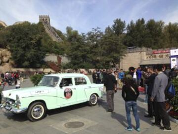 Varias personas observan un Fenghuang 760, de 1973, al pie de la Muralla China, donde coleccionistas de vehículos de época y vendedores de este tipo de autos iniciaron este fin de semana en un viaje de 1.600 kilómetros entre las dos principales ciudades de China, Pekín y Shanghai, con el que quieren fomentar la afición a los grandes clásicos del motor en el país asiático.