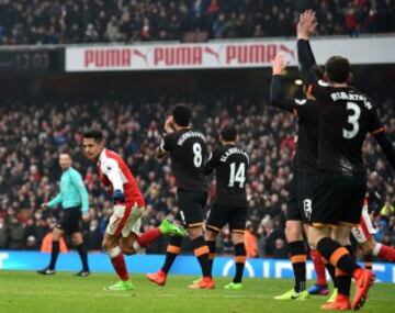 Arsenal's Chilean striker Alexis Sanchez (L) celebrates after scoring the opening goal as Hull players appeal for a hand ball against Sanchez during the English Premier League football match between Arsenal and Hull City at the Emirates Stadium in London on February 11, 2017.  / AFP PHOTO / Glyn KIRK / RESTRICTED TO EDITORIAL USE. No use with unauthorized audio, video, data, fixture lists, club/league logos or 'live' services. Online in-match use limited to 75 images, no video emulation. No use in betting, games or single club/league/player publications.  / 