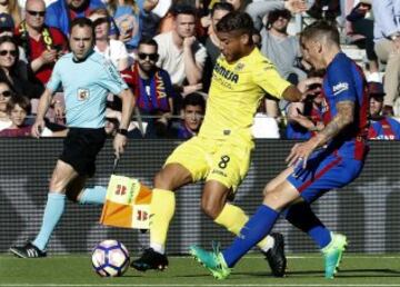 El defensa francés del FC Barcelona Lucas Digné intenta impedir el avance de Jonathan Dos Santos (c), del Villareal.