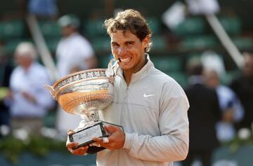 Nadal poses with the trophy after defeating Novak Djokovic at the French Open, June 2014.