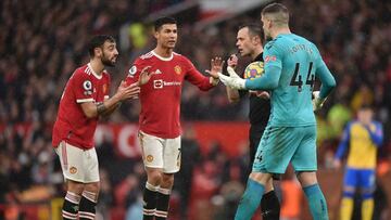 MANCHESTER, ENGLAND - FEBRUARY 12: Cristiano Ronaldo and Bruno Fernandes of Manchester United speak to Referee Stuart Attwell during the Premier League match between Manchester United and Southampton at Old Trafford on February 12, 2022 in Manchester, Eng