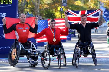 Los ganadores de la prueba masculina en silla de ruedas de la Maratón de Nueva York Marcel Hug, Daniel Romanchuk y David Weir posan tras finalizar la carrera.  