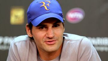 Roger Federer posa con una gorra con su logotipo RF durante una rueda de prensa.