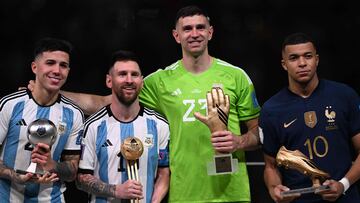 Argentina's midfielder #24 Enzo Fernandez, Argentina's forward #10 Lionel Messi, Argentina's goalkeeper #23 Emiliano Martinez and France's forward #10 Kylian Mbappe pose on the podium after respectively receiving the Young Player, Golden Ball, Golden Glove and Golden Boot awards, during the Qatar 2022 World Cup trophy ceremony after the football final match between Argentina and France at Lusail Stadium in Lusail, north of Doha on December 18, 2022. (Photo by Kirill KUDRYAVTSEV / AFP)