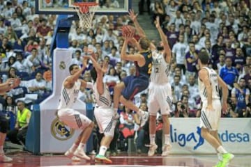 El jugador del FC Barcelona Oleson (c) entra a canasta ante varios defensores del Real Madrid, durante el primer partido de la final de la Liga ACB disputado esta noche en el Palacio de Deportes en Madrid. 