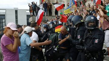 Police officers scuffle with a protester in front of the Reichstag Building during a rally against the government's restrictions following the coronavirus disease (COVID-19) outbreak, in Berlin, Germany, August 29, 2020. REUTERS/Christian Mang