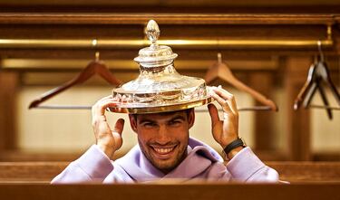 Carlos Alcaraz posa sonriente, en el interior del vestuario, con el trofeo de campeón del torneo de Queen’s sobre su cabeza. El tenista murciano se proclamó campeón del torneo londinense por segunda vez, tras superar en la final al checo Jiri Lehecka. Su proxima cita, también en la hierba londinense, será en el All England Club, en Wimbledon. 