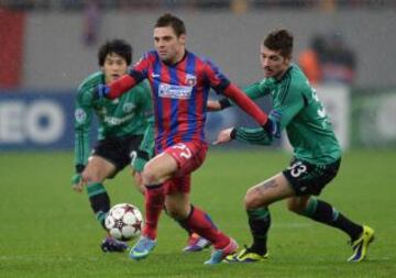 El jugador del Steaua Adrian Popa se disputa el balón con el jugador del Schalke Roman Neustaedter, durante el partido del grupo E de la Liga de Campeones, en el estadio National Arena de Bucarest (Rumania).