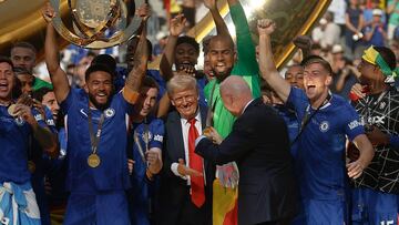 EAST RUTHERFORD, NEW JERSEY - JULY 13: FIFA President Gianni Infantino (R) directs U.S. President Donald Trump away from the celebrating Chelsea footballers after they won the final match of the FIFA Club World Cup at MetLife Stadium on July 13, 2025 in East Rutherford, New Jersey. This is the first time in the history of the FIFA CWC that the United States has hosted the competition, one year before the U.S., Mexico and Canada are scheduled to host the World Cup in 2026. Chip Somodevilla/Getty Images/AFP (Photo by CHIP SOMODEVILLA / GETTY IMAGES NORTH AMERICA / Getty Images via AFP)
