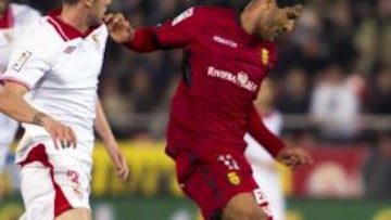 El centrocampista argentino del Mallorca, Fernando Tissone, conduce el bal&oacute;n ante el defensa del Sevilla, Fernando Navarro, durante el encuentro correspondiente a la vig&eacute;simo s&eacute;ptima jornada de primera divisi&oacute;n, que disputan esta noche en el Iberostar Estadio de la capital balear. 