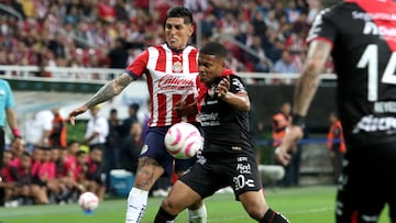 Guadalajara's midfielder Victor Guzman (L) and Atlas' Colombian midfielder Juan Manuel Zapata vie for the ball during their Mexican Apertura tournament football match, at the Akron stadium, in Guadalajara, Jalisco State, Mexico, on October 7, 2023. (Photo by ULISES RUIZ / AFP)