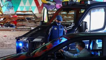 A local police officer checks documents at a checkpoint in the Villaverde neighbourhood during a partial lockdown between and within areas in six districts, amid the outbreak of the coronavirus disease (COVID-19), in Madrid, Spain September 23, 2020. REUTERS/Sergio Perez