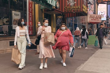 Un grupo de mujeres con mascarilla van de compras por las calles de Nueva York.