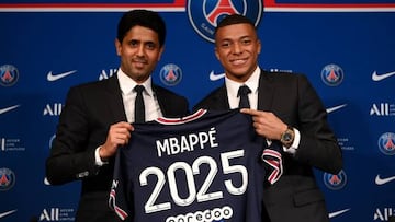 Paris Saint-Germain's CEO Nasser Al-Khelaifi (L) and French forward Kylian Mbappe (R) pose with a jersey at the end of a press conference at the Parc des Princes stadium in Paris on May 23, 2022, two days after the club won the Ligue 1 title for a record-equalling tenth time and its superstar striker Mbappe chose to sign a new contract until 2025 at PSG rather than join Real Madrid. (Photo by FRANCK FIFE / AFP) (Photo by FRANCK FIFE/AFP via Getty Images)