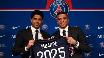 Paris Saint-Germain's CEO Nasser Al-Khelaifi (L) and French forward Kylian Mbappe (R) pose with a jersey at the end of a press conference at the Parc des Princes stadium in Paris on May 23, 2022, two days after the club won the Ligue 1 title for a record-equalling tenth time and its superstar striker Mbappe chose to sign a new contract until 2025 at PSG rather than join Real Madrid. (Photo by FRANCK FIFE / AFP) (Photo by FRANCK FIFE/AFP via Getty Images)