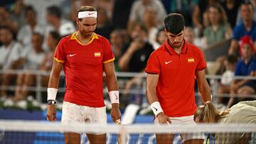 Spain's Rafael Nadal (L) and Spain's Carlos Alcaraz (R) check the final line call with chair umpire Miriam Bley (R) as they lose against US' Austin Krajicek and US' Rajeev Ram in their men's doubles quarter-final tennis match on Court Philippe-Chatrier at the Roland-Garros Stadium during the Paris 2024 Olympic Games, in Paris on July 31, 2024. (Photo by CARL DE SOUZA / AFP)
