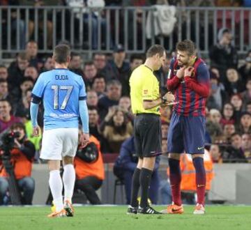 Piqué pide explicaciones al árbitro Clos Gómez tras mostrarle la tarjeta amarilla.