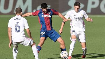 Levante's Spanish midfielder Gonzalo Melero (C) vies with Real Madrid's Uruguayan midfielder Federico Valverde (R) during the Spanish League football match between Levante UD and Real Madrid CF at La Ceramica stadium in Vila-real on October 4, 2