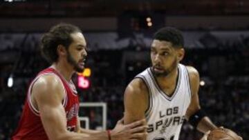 Joakim Noah defiende a Tim Duncan.