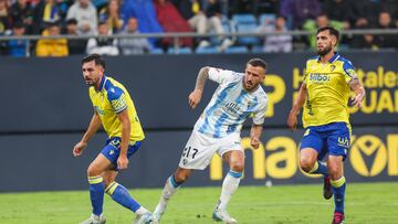 Chust y Glauder intentan parar a Dioni en el primer tanto del Málaga.