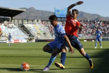 El jugador de O'Higgins, Brian Torrealba, centro, disputa el balón con Sebastian Jaime de Universidad Católica.