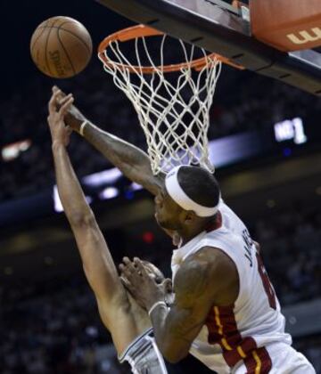 Tim Duncan de San Antonio Spurs y LeBron James de Miami Heat luchan por un rebote