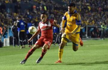 El jugador de Tigres José Rivas (d) disputa el balón con Christian Cuevas (i) de Toluca hoy, jueves 3 de diciembre de 2015, durante el partido de ida de las semifinales del Torneo Apertura del fútbol mexicano, realizado en el estadio Universitario de la ciudad de Monterrey.