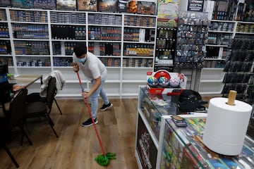 Incidencias en la capital malagueña con motivo de las precipitaciones. Unos jóvenes limpian en su establecimiento los daños provocados por las lluvias.