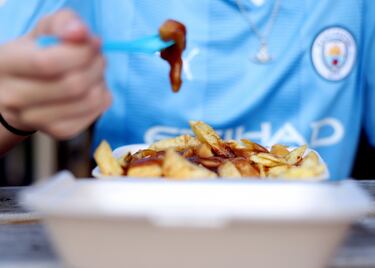 Un aficionado del Manchester City coge fuerzas para disfrutar del encuentro de Champions frente al Estrella Roja.