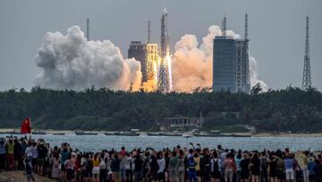 TOPSHOT - People watch a Long March 5B rocket, carrying China's Tianhe space station core module, as it lifts off from the Wenchang Space Launch Center in southern China's Hainan province on April 29, 2021. (Photo by STR / AFP) / China OUT