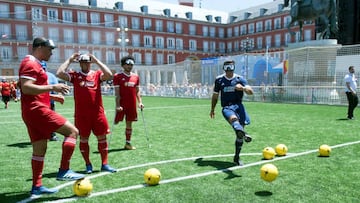 Portuguese former football player Luis Figo (R) shoots a penalty kick blindfolded during the UEFA&#039;s #EqualGame campaign at the Plaza Mayor square in Madrid on May 31, 2019 on the eve of the UEFA Champions League final football match between Liverpool