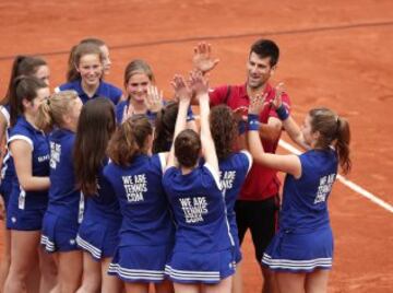 Novak Djokovic celebra con las recogepelotas su primera victoria en Roland Garros.
