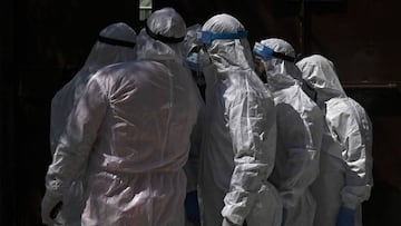 Medical staff wearing Personal Protective Equipments (PPE) close a school gate as others inside collect Rapid Antigen Test (RAT) from shopkeepers and salesman for the Covid-19 coronavirus, in Srinagar on September 8, 2020. - India overtook Brazil on Septe