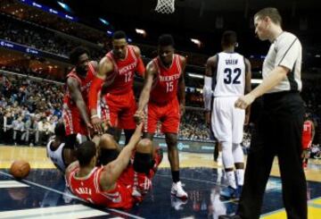 Patrick Beverly, Dwight Howard y Clint Cappella ayudan a levantarse a Trevor Ariza.