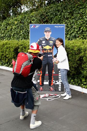 Una aficionada posa con la figura de cart車n de Max Verstappen.