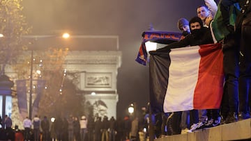 Football fans, next to the Arc de Triomphe, celebrates after France's victory over Morocco in the Qatar 2022 World Cup semi-final, on the Champs-Elysees in Paris on December 14, 2022. (Photo by Thibaud MORITZ / AFP)