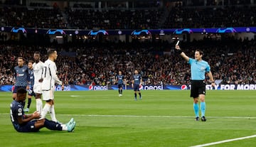 El árbitro turco, Halil Umut Meler, muestra la cartulina amarilla a Lucas Vázquez tras señalar el punto de penalti. El defensa blanco derriba con un agarrón a Cristian Borja en el minuto 3 de partido.