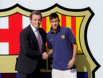 Neymar estrecha la mano a Sandro Rosell, presidente del Barcelona.