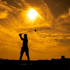 Jugando al golf en la puesta de sol