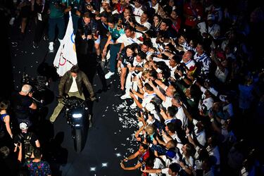 Tom Cruise saliendo del estadio con la bandera olímpica en una motocicleta con destino a la próxima sede de los Juegos Olímpicos de Los Ángeles 2028.