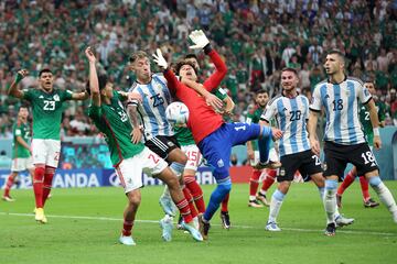 El argentino Lisandro Martínez pelea un balón entre los jugadores mexicanos Kevin Álvarez y Guillermo Ochoa. 

 
